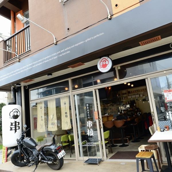 店頭に揺れる大きな提灯と、店内に飾られたポップなアートポスターが目を引く、遊び心たっぷりの空間です。木目を基調とした温かみのある内装に、鮮やかなグリーンのチェアがモダンなアクセントを添えています。お一人様からグループまで、肩肘張らずに博多スタイルの本格焼き鳥を楽しめる、明るく活気ある雰囲気です。