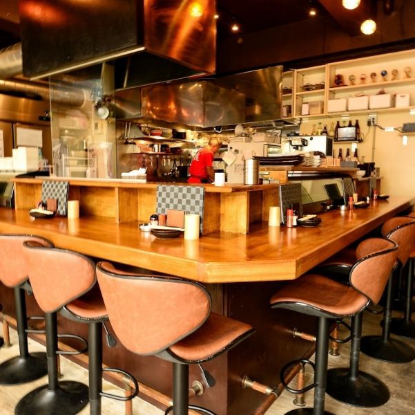 オープンキッチンのライブ感を楽しめるカウンター席と、ゆったり座れるテーブル席を完備。どこかバルのような雰囲気も持ち合わせており、友人との飲み会や仕事帰りの一杯に最適です。壁に広がるウッドパネルが落ち着きを与え、美味しい香りに包まれながら、ついつい長居したくなるような親しみやすさが魅力です。