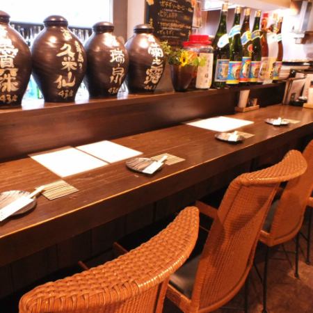 【2F】古酒が目の前にあるカウンター席は沖縄ムード満点！シーンに合わせてご活用ください。