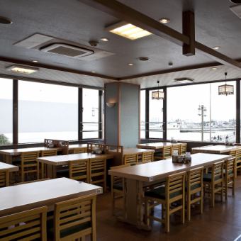 【2階レストラン】1名様から大人数でのご利用も可能なテーブル席は、4名テーブル、6名テーブル、2名テーブルをそれぞれご用意ございます。湘南海岸の大パノラマとともにお食事をお楽しみいただけます。