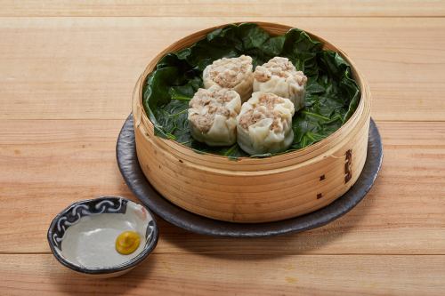 Shumai wrapped in kale and steamed in a bamboo steamer