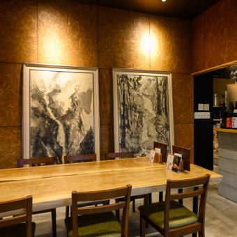店内中央には、木の温もりを感じる立派な一枚板風の大きなテーブル席をご用意しております♪壁に飾られた大迫力のアート作品が目を引く、洗練されたお洒落な空間です◎ゆったりとお座りいただける広々としたお席なので、グループでのご利用にもおすすめ！奥にはお一人様でも気軽に過ごせるカウンター席もございます♪
