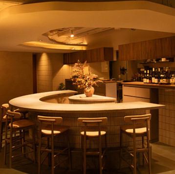 片側一面がガラス張り の店内は、席ごとに異なる幻想的な世界観が広がります。水面のライティングが美しいテーブル席、雲を表現したカウンター、滝を思わせる個室と、おしゃれな新店 の細部にまでこだわりが光ります。