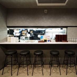 【1階カウンター席】今日は一人で飲みたい気分！そんな方のために1階フロアにカウンター席を5席ご用意しております。料理が出来上がる様子を眺めたり、料理長やスタッフとおしゃべりしたりと、お一人様の時間を満喫いただけます。デートや同僚とのサクのみなど、お一人様はもちろん、お二人様でも気軽にお使いください。
