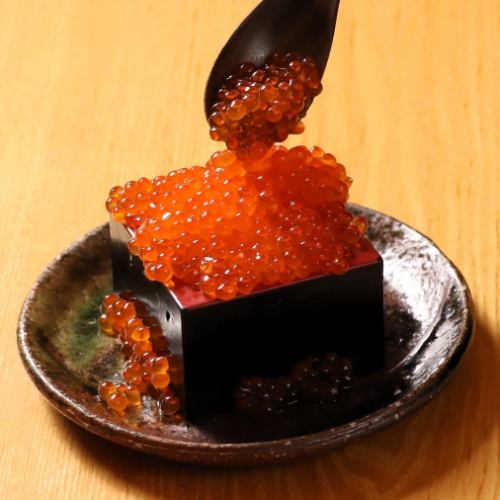 Spilled salmon roe and rice in a wooden box