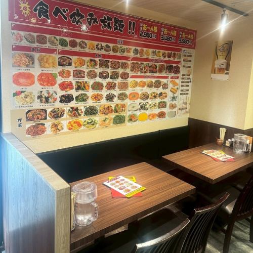 木目調の落ち着いたテーブル席は、4名様でゆったりとお食事を楽しめる空間です。壁には豊富な中華料理の写真が並び、メニュー選びもワクワク！会社帰りの飲み会やご家族・ご友人との食事にぴったり♪