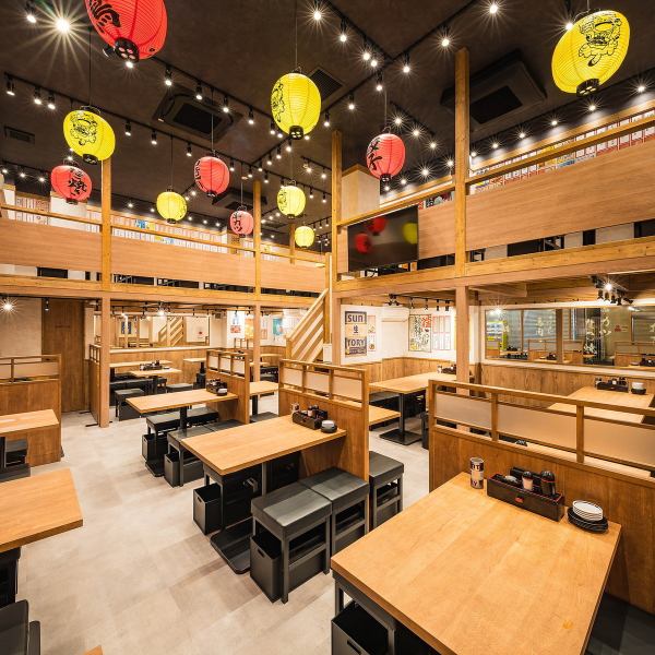 【活気あふれる大衆空間】店内に一歩入ると、色とりどりの提灯が灯る活気満点の大衆酒場空間が広がります。大人数でもゆったり座れる広いテーブル席がずらりと並び、仕事帰りの飲み会はもちろん、会社宴会や友人との集まりにも最適◎