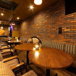 【テーブル席:2~25名様】温かみのあるインテリアと間接照明に彩られたワンフロアの広々とした空間。ゆったりとしたソファ席やクッション性のある椅子を配置したテーブル席で、リラックスしてお酒と料理をご堪能いただけます。友人同士の少人数飲み会から、大人数宴会まで、さまざまなご用途でお楽しみください。