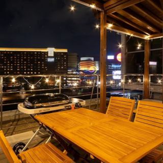 【テラス/テーブル席:10名様まで】ビル最上階の5階から中洲を見下ろせるテラスです。ウッディでおしゃれなテラスは、昼と夜で全く違う雰囲気を味わえます。屋根・冷暖房完備のため、季節や天気に左右されずいつでも快適にご利用いただけます。心地よい風を感じながら優雅にBBQを楽しみませんか?
