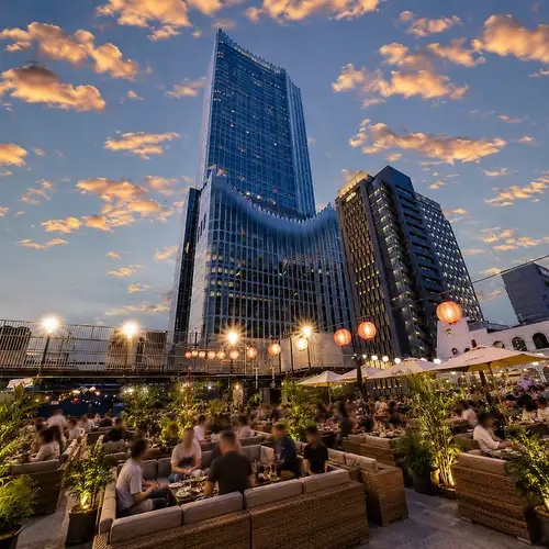 An open rooftop terrace space with views of the Shinjuku nightscape.