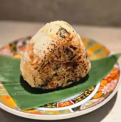 Grilled rice ball made with shakushina (a type of mustard green) from Saitama Prefecture and sea bream.