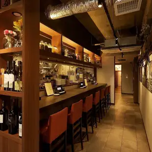 木の温もりあふれるロングカウンター席。目の前に広がるオープンキッチンで、ライブ感のあるひとときを楽しめます。落ち着いた照明とゆったりしたお席で、一人でも気軽に、ゆっくりと過ごせる特別な空間です。