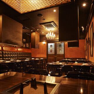 【テーブル席】シャンデリアに照らされたシックな空間には、重圧感のあるソファーや落ち着いた雰囲気のテーブル席をご用意しております。テーブル席では、最大10名様までひとつのスペースでご一緒にお食事をお楽しみいただけます。