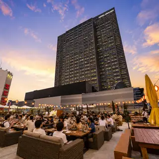 屋頂露台座位，周圍環繞著新宿的摩天大樓，真可謂都市綠洲。您可以一邊享用烤肉和燒烤，一邊欣賞開闊壯麗的景色。這裡地理位置絕佳，無論是下班後小酌一杯，或是舉辦大型宴會，都是完美之選！