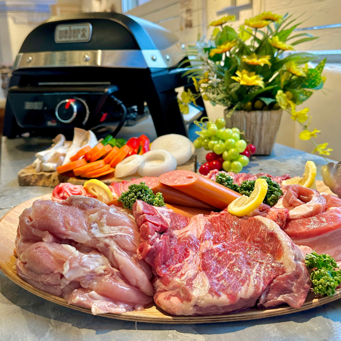烤肉架和一套食物,包括厚切肉、雞肉和義大利燻火腿,擺放在木板上(澀谷 Pikarie)