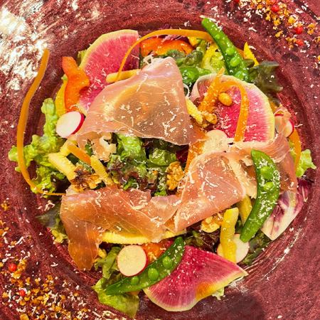 Caesar salad with prosciutto and colorful vegetables