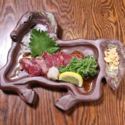 Raw horse meat sashimi covered with green onions and seared