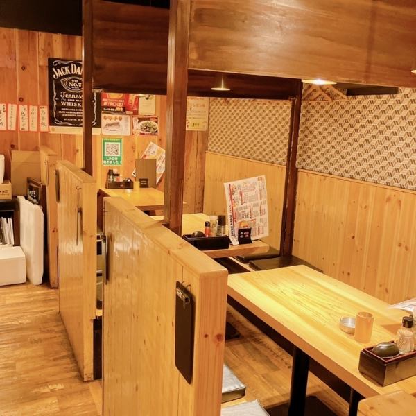 店内はオレンジ色の温かい明かりで照らされており、木をあしらったテーブル席が配置されています。4名様が座れる広々としたテーブルは、ゆったりとした空間でお食事を楽しむことができます。