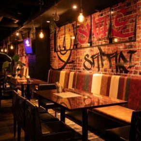 【50名様まで/ソファー席】記念日デートや女子会には、片側ソファーのテーブル席がおすすめです。心地よい緑やブルックリンスタイルを思わせるヴィンテージなレンガ壁は、どこを切り取っても写真映え抜群★ゆとりある席配置で、隣を気にせずリラックスしてお過ごしいただけます。