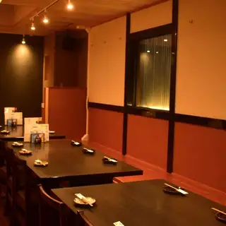木の温もりを感じる落ち着いたテーブル席は、ゆったりと会話と料理を楽しめる空間。ご友人同士のお食事やご家族での利用、仕事帰りの飲み会にも使いやすく、人数に応じて柔軟に対応可能です。店内奥には複数卓をまとめて使える配置もあり、少人数の宴会や会食にもおすすめ。