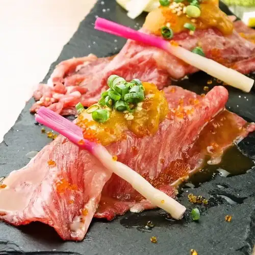 两块新潟和牛寿司,上面放有海胆。