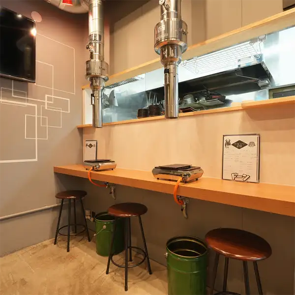 【お一人様から少人数のお食事に】店内にはテーブル席に加え、カウンター席もご用意。お一人様でのサシ飲みから、友人やカップルでの気軽なお食事まで、幅広いシーンでご利用いただけます。背中合わせのお席も含め、賑やかで親しみやすいお店の個性を感じながら、美味しいお肉とお酒をご堪能ください。