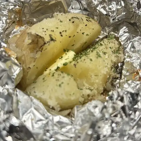 Charcoal-grilled potato with butter