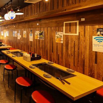 壁に貼られたメニューやポスターが下町ならではの情緒を醸し出しつつ、清潔感のあるモダンなテーブルセットが整えられた空間です。赤い座面のスツールがアクセントとなり、どこか懐かしくも新しい居心地の良さを感じさせます。無料Wi-Fi完備など利便性も高く、観光の合間や仕事帰りにも気軽に立ち寄れるお店です。