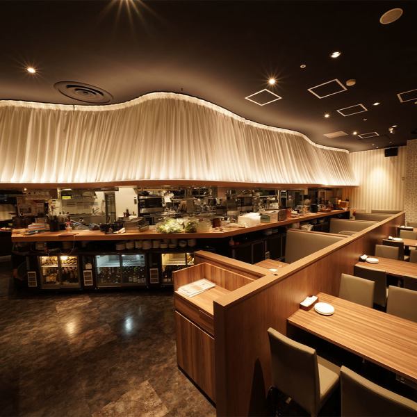 全席から眺められるオープンキッチンが象徴に!!お客様に美味しい料理を楽しんでもらうために一生懸命働くスタッフをご覧いただけます。まるで欧州の劇場をイメージして作り上げた空間は非日常的でラグジュアリーながらホッと一息ついて休める居心地の良さ。高い天井は開放感を提供し、日々のストレスを緩和させてくれます。