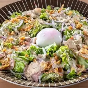 Caesar salad with soft-boiled egg and bacon