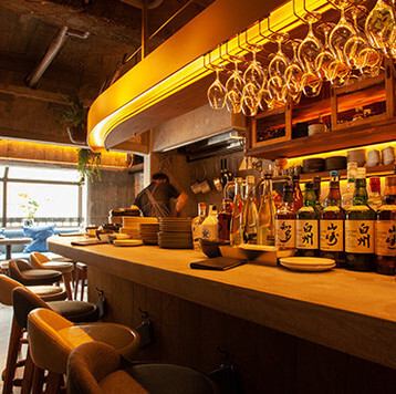 <p>【落ち着いた空間】無機質な空間に温かみのある照明と緑の植物を配し、居心地の良い雰囲気を演出しています。スタイリッシュでありながらも、どこか懐かしい「屋根裏の台所」をイメージした空間で、ゆったりとお食事をお楽しみいただけます。</p>